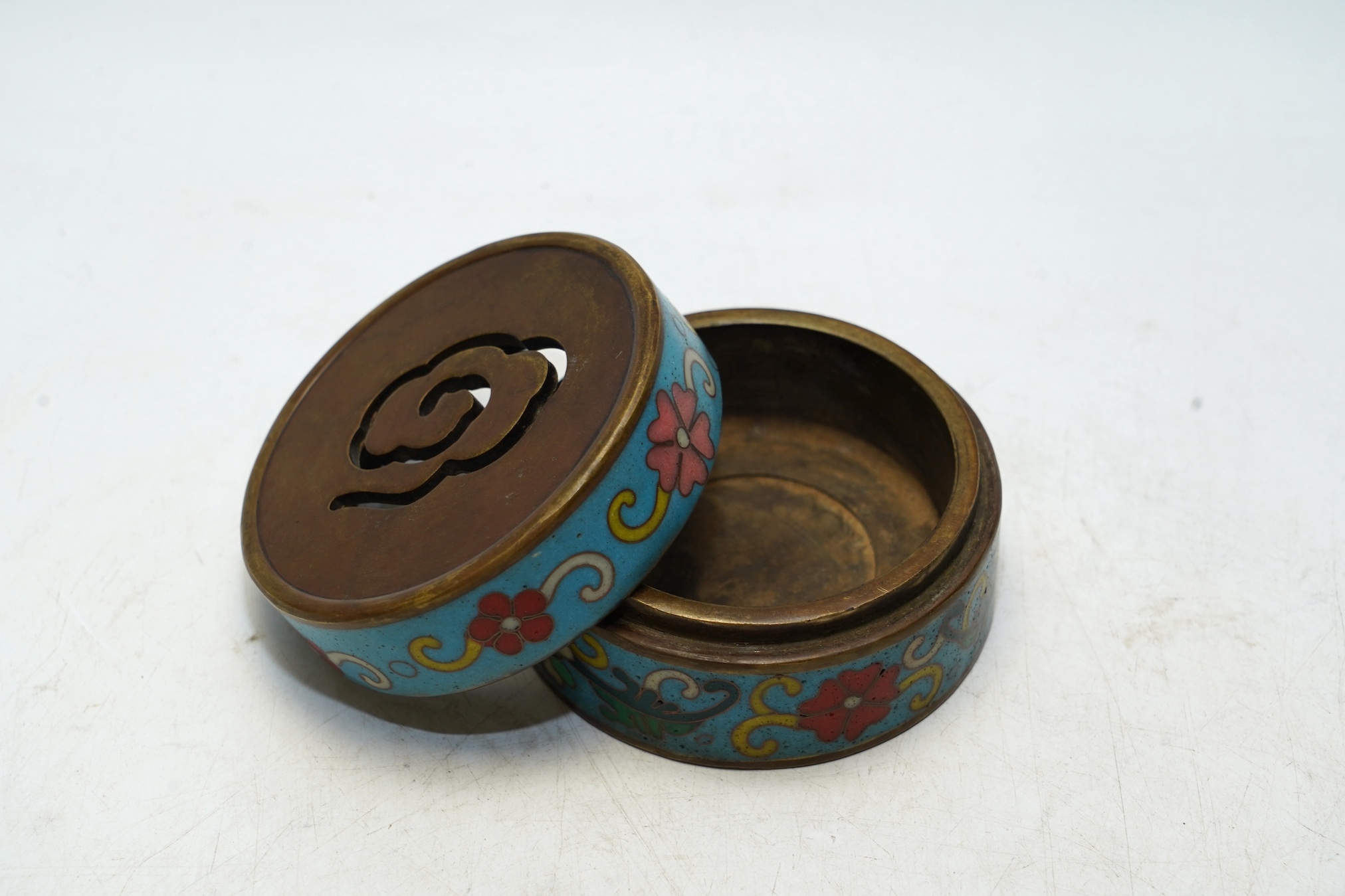 A heavy Chinese cloisonné incense box enamelled with flowers, apocryphal Qianlong mark 8cm in diameter. Condition - fair